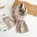Detalle de bufanda de lana beige trenzada con textura gruesa y etiqueta decorativa tejida - Beige