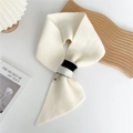 Detalle de bufanda de punto crema con hebilla de contraste y textura suave y fina - Blanco Crema Bicolor