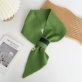 Detalle de bufanda de punto verde hierba con correa negra y etiqueta tejida blanca - Verde bicolor