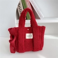 Dettaglio di una borsa tote rossa pelosa con consistenza morbida e ampia tracolla - Borgogna