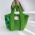 Detail of green faux shearling tote bag with brand label and fluffy texture - Green