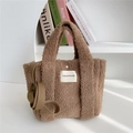 Detail of brown plush crossbody tote bag featuring soft fleece texture and round handles - Brown