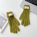 Detail of cable knit green gloves with folded cuffs and woven label on a desk - Grass Green