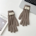 Detail of brown cable-knit winter gloves featuring a stylish fabric brand label on the cuff - Beige Coffee
