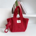 Detail of red plush tote bag showing soft teddy fabric texture and brand label - Burgundy