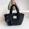 Detail of black faux shearling tote bag with brand label and long shoulder strap - Black