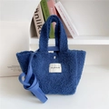 Close-up of blue teddy plush handbag showing fuzzy texture and metal magnetic closure - Blue