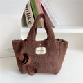 Detailed view of brown plush crossbody bag with soft faux fur texture and woven label - Brown