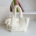 Detail of white fluffy faux shearling handbag with brand label and crossbody strap - Cream