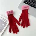 Detail of red knit gloves with pink faux shearling cuffs and decorative leather label - One Size / Red