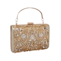 Detailed view of hollow metal floral patterns and sparkling rhinestones on an evening clutch - Gold