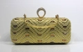 Détail du fermoir anneau et du motif chevron en strass sur une pochette de soirée dorée - Doré