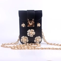 Nahaufnahme der schwarzen PU-Handytasche mit weißen Perlblumen und goldener Kette - Schwarz/Perlenkette