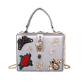 Detail of silver evening bag featuring butterfly embroidery, pearl flowers, and jewel accents - Silver