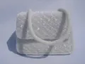 Detail einer handgefertigten weißen Perlen-Abendtasche mit Wellenstruktur und Perlenriemen - Weiß