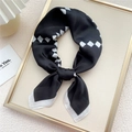 Elegante foulard in seta satinata con motivo geometrico bianco e nero annodato a fiocco - Griglia Nera