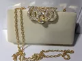 Détail du fermoir doré avec strass sur pochette de soirée en velours avec chaîne - Blanc Cassé