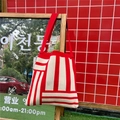 Detalle del bolso tote de punto a rayas rojas y crema con textura gruesa y bandolera - Rayas Rojas