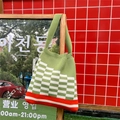Detail of green and white checkered knit tote bag with red stripes on a wooden signpost - Light Green Checkerboard