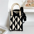 Dettaglio macro della trama geometrica a maglia e manico in silicone della mini borsa a tracolla - Triangolo Nero e Beige