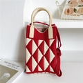 Dettaglio della borsa in maglia a rombi rossa e beige con manico tondo e trama morbida - Rosso e Beige Triangolo