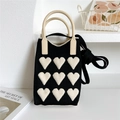 Close-up of black knit tote bag with white heart patterns and beige round handles - 11*25cm / Black Background with White Hearts