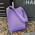 Detailed knit texture of purple tote bag with pink contrast shoulder strap in natural light - Purple
