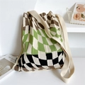 Detail of knitted tote bag with green checkerboard pattern and brand logo tag - Three-color Checkerboard