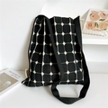Detail of black knit tote bag showing the white grid pattern and HSNM woven label - Black Small Polka Dot Grid