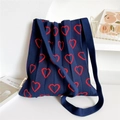 Detail view of navy pleated knit tote bag with red heart pattern and wide shoulder strap - Navy Hollow Heart