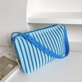Detail of blue striped knitted shoulder bag featuring adjustable silicone strap and side tag - 25*20cm / Blue