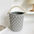 Detail of dark grey knit bucket bag featuring 3D polka dot texture and pearl handle - 20cm x 20cm x 15cm / Gray