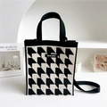 Detalle del bolso de punto de pata de gallo blanco y negro con logo y cierre magnético - Pata de Gallo Negro