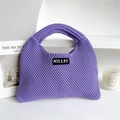 Close-up of purple knit tote bag with woven texture and a minimalist brand label - Purple