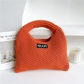 Close-up of vibrant orange knitted tote bag with thick texture on a minimalist background - Orange