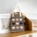 Detailed knit texture of brown mini tote bag featuring nine colorful heart patterns - Coffee Heart