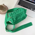 Macro detail of grass green knit crossbody bag texture with wide nylon shoulder strap - Green