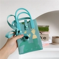 Close-up of mint green knitted handbag featuring a yellow giraffe pattern and gemstone buckle - Giraffe/Rabbit Pattern (Mint Green)