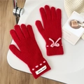 Detail von roten Strickhandschuhen mit rosa Schleife und gerippten Bündchen für Damen - Rot