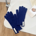 Detalle de guante de lana azul real con etiqueta blanca tejida en el puño - Talla única / Azul oscuro