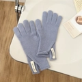 Detail of light blue knitted wool gloves showing soft texture and brand label - One Size / Blue