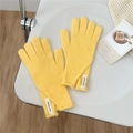 Detail of yellow knit wool gloves featuring minimalist Jennie Wool white fabric labels - One Size / Yellow