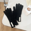 Classic black knitted wool gloves with Jennie Wool label in a cozy home setting - One Size / Black