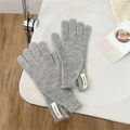 Detail of light gray wool knit gloves with Jennie Wool label on minimalist white chair - One Size / Light Gray