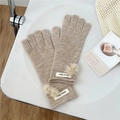Detail view of beige knitted gloves with soft pom-pom accents and elegant woven brand labels - One Size / Beige Coffee