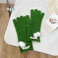 Close-up of green knitted five-finger gloves with white fluffy balls on a chair - One Size / Dark Green