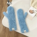 Detail of sky blue fluffy mittens showing soft faux fur texture and brand label - Blue