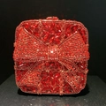 Macro detail of red rhinestone crystal clutch bag with elegant bow design and metal clasp - Red