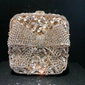 Detailed close-up of luxurious golden bow clutch with sparkling crystals and metal frame - Gold White Zirconia