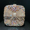 Macro detail of golden evening clutch with diamond bow and colorful crystal leaf patterns - Gold AB